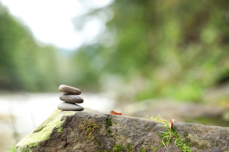 Balancing zen pebble stones outdoors against blurred background. Space for textの写真素材