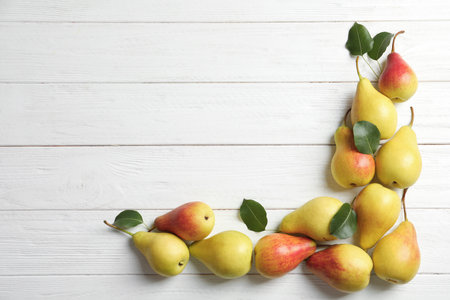Flat lay composition with ripe pears on white wooden background. Space for textの写真素材