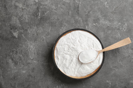 Bowl of baking soda with spoon and space for text on table, top viewの写真素材
