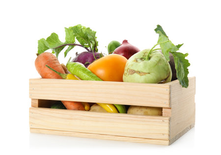 Fresh ripe vegetables in wooden crate on white backgroundの写真素材