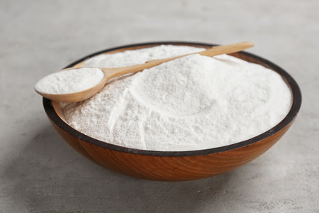 Bowl and spoon with baking soda on gray tableの写真素材