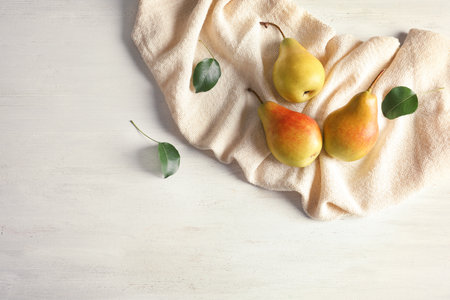 Flat lay composition with ripe pears on white wooden background. Space for textの写真素材