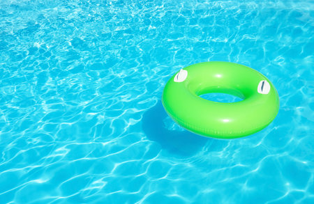 Inflatable ring floating in swimming pool on sunny day. Space for textの写真素材