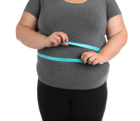 Overweight woman with measuring tape on white background, closeupの写真素材