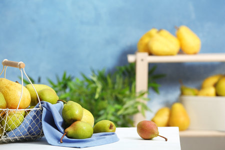Fresh ripe pears on light table against blurred backgroundの写真素材