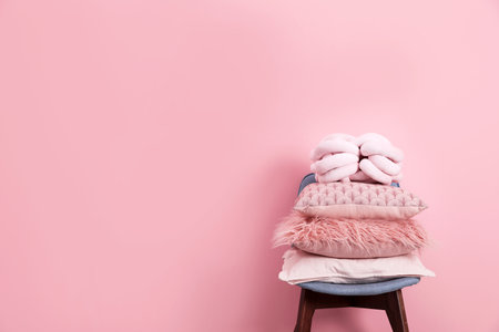 Chair with many different pillows and space for text on color backgroundの写真素材