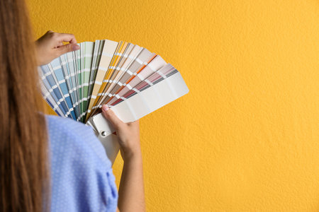 Female interior designer with palette samples on color background, closeup. Space for textの写真素材