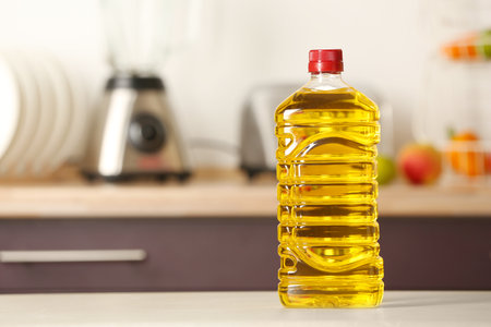 Bottle of oil on table against blurred background. Space for textの写真素材