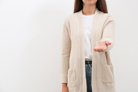 Woman giving helping hand on light background. Space for textの写真素材