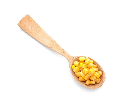 Wooden spoon with corn kernels on white background, top viewの写真素材