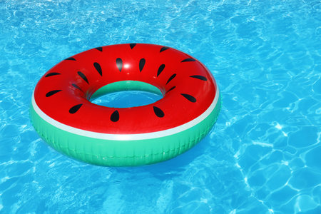 Inflatable ring floating in swimming pool on sunny day