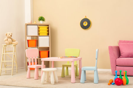 Cozy kids room interior with table, sofa and shelving unitの写真素材