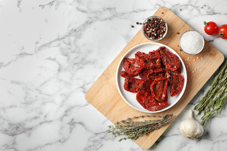 Flat lay composition with dried tomatoes and space for text on marble tableの写真素材