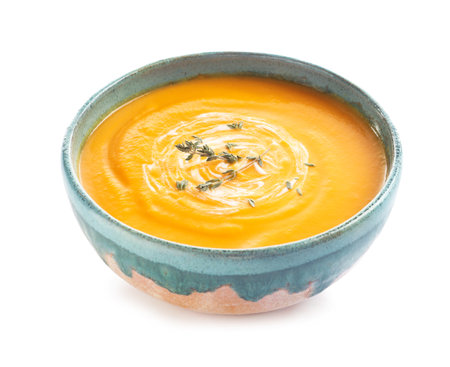 Delicious pumpkin cream soup in bowl on white backgroundの写真素材