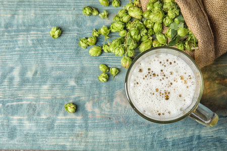 Flat lay composition with tasty beer, fresh green hops and space for text on wooden backgroundの写真素材