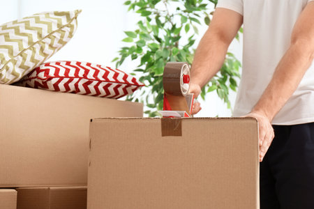 Man packing carton box indoors, closeup. moving day