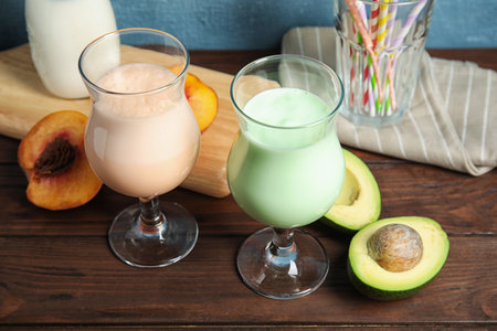 Glasses with delicious milk shakes and ingredients on tableの写真素材