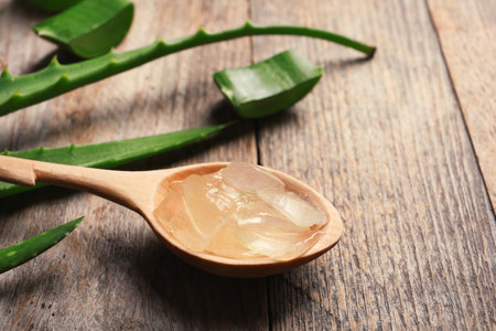 Spoon with aloe vera gel on wooden backgroundの写真素材