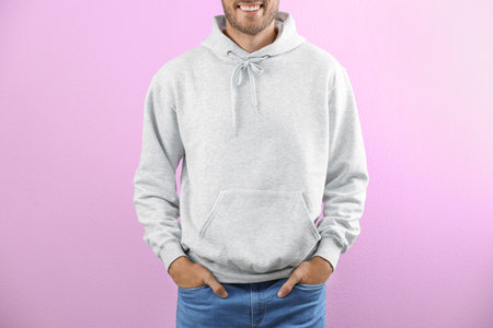 Man in hoodie sweater on color background. space for designの写真素材