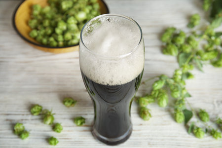 Composition with tasty beer and fresh green hops on wooden tableの写真素材