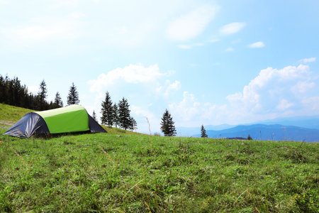 Small camping tent in mountains on sunny dayの写真素材