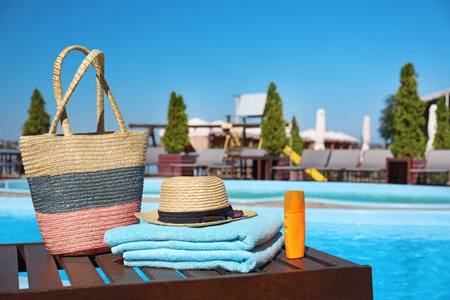 Beach accessories near swimming pool on sunny day