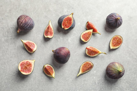 Flat lay composition with whole and cut purple figs on gray backgroundの写真素材