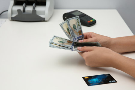 Woman with money and credit card at table, closeupの写真素材
