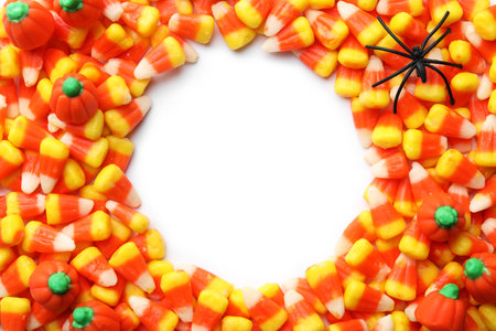 Colorful candy corns for Halloween party on white background, top view