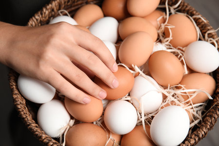 Woman with basket full of raw chicken eggs, closeupの写真素材