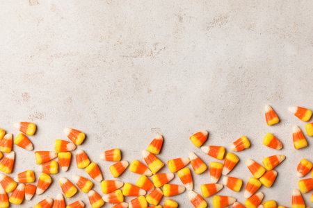 Flat lay composition with delicious candy corns and space for text on gray background
