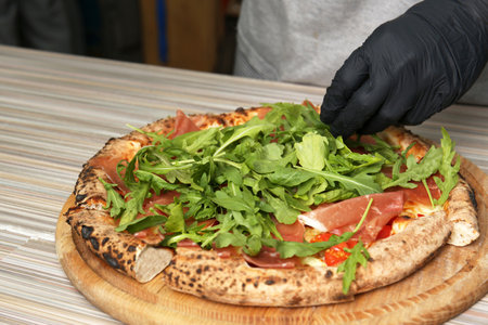 Professional chef preparing Italian oven baked pizza in restaurant, closeupの写真素材