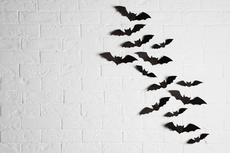 Paper bats on brick wall with space for text. halloween decor