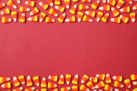 Flat lay composition with delicious candy corns and space for text on color background