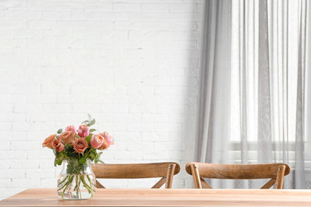 Vase with beautiful flowers as element of interior design on table in room. Space for textの写真素材