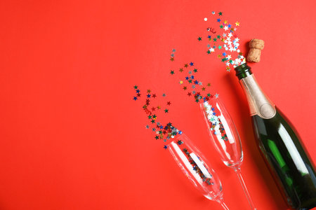 Creative flat lay composition with bottle of champagne and space for text on color backgroundの写真素材
