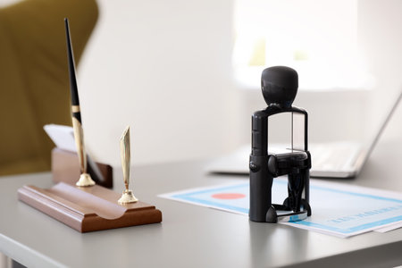 Automatic stamp and documents on desk in notary's officeの写真素材