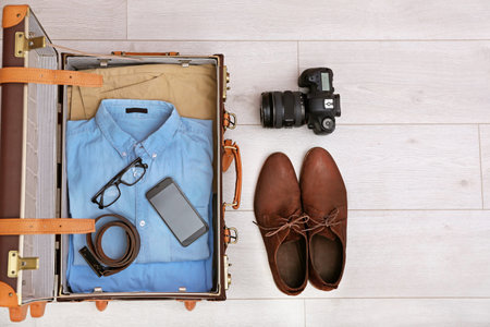 Packed suitcase on wooden background, top view. Space for textの写真素材