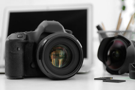 Digital camera on white table. Equipment for professional photographerの写真素材