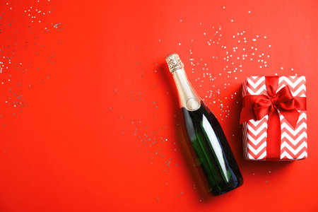 Creative flat lay composition with bottle of champagne and space for text on color backgroundの写真素材