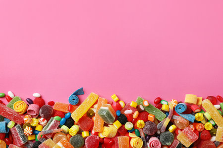Flat lay composition with delicious colorful candies and space for text on color backgroundの写真素材