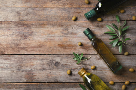Flat lay composition with bottles of olive oil and space for text on wooden backgroundの写真素材