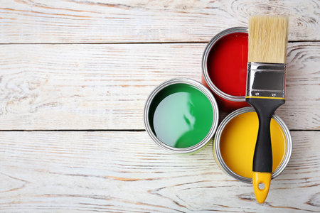 Cans with paint and brush on wooden background, top view. Space for textの写真素材