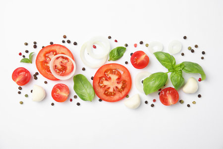 Fresh green basil leaves, tomatoes and mozzarella on white background, top viewの写真素材