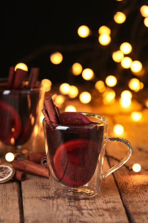 Glass cup with mulled wine on table against blurred backgroundの写真素材
