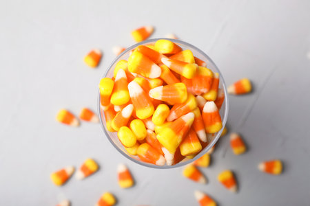 Glass of tasty candy corns on gray background, top viewの写真素材
