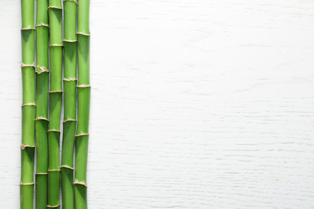 Green bamboo stems and space for text on wooden background, top viewの写真素材