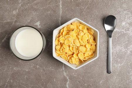 Flat lay composition with healthy cornflakes in bowl on table