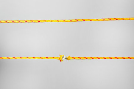 Intact and frayed ropes on gray background