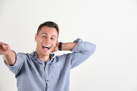 Laughing man taking selfie on white background. Space for textの写真素材